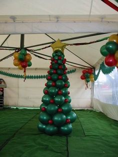 a christmas tree made out of balloons in a tent