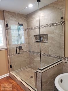 a walk in shower sitting next to a white sink