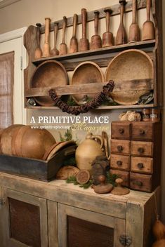 an old wooden cabinet with pots and pans on it's shelf, next to other items