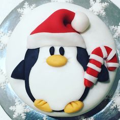 a cake decorated with a penguin wearing a santa hat