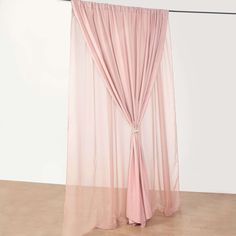 a pink sheer curtain hanging on a wall