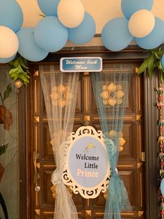 a welcome little prince sign on the front door to a house decorated with blue and white balloons