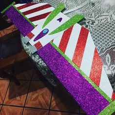 a close up of a paper mache on a wooden table with purple and green glitters