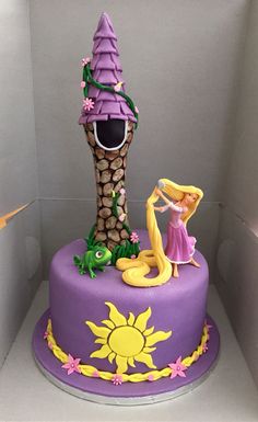 there is a purple cake with a princess on top and a tree house in the background