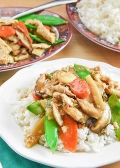 two plates with rice, chicken and vegetables on them