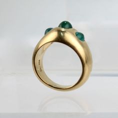 A very fine Gubelin 18k gold emerald cabochon ring.  With three smooth oval emerald cabochons bezel set in a regal, signet style 18k gold thick band ring.  A wonderful ring from one of the worlds finest jewelers!  Date: 20th Century  Overall Condition: It is in overall good, as-pictured, used estate condition  Condition Details: There is some very light roughness surface scratches to the tops of the emeralds, and other signs of expected light wear consistent with age.  Fineness: Marked 750 for 1 Thick Band Ring, Gold And Emerald, Emerald Cabochon, Worlds Finest, Cabochon Ring, Fine Jewels, Three Stone Rings, Three Stone, Bezel Setting