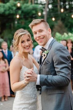 a bride and groom dance together at their wedding reception in front of an outdoor crowd