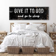 a bed with white linens and baskets on the headboard is in front of a sign that says give it to god and go to sleep