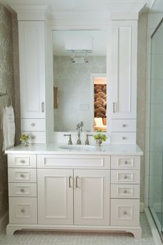 a bathroom with two sinks and a large mirror over it's vanity area, in front of a walk - in shower