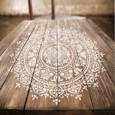 a wooden table with white designs painted on it