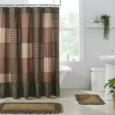 a bathroom with a shower curtain and rugs on the floor