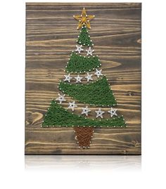 a christmas tree made out of grass on top of a wooden board with gold stars