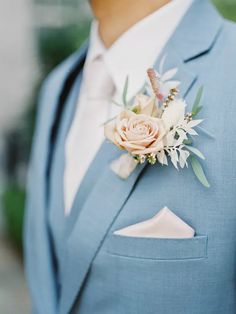 a man wearing a blue suit and flower boutonniere