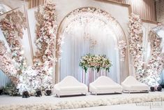 an elegant wedding setup with white chairs and flowers