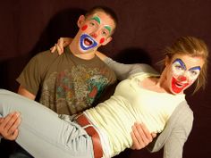 two people with clown makeup on their faces posing for the camera while one person has his arm around the other's back