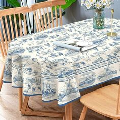 a dining room table covered with a blue and white toiler print linens