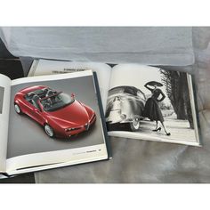 an open book with pictures of cars on it and a woman standing next to the car