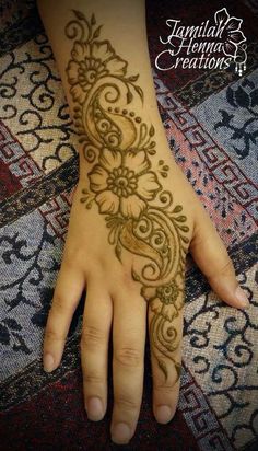 a woman's hand with henna tattoos on it