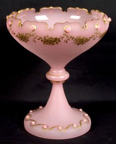 a pink glass vase with gold trimmings on it