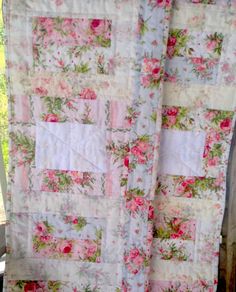 a pink and white quilt with flowers on it