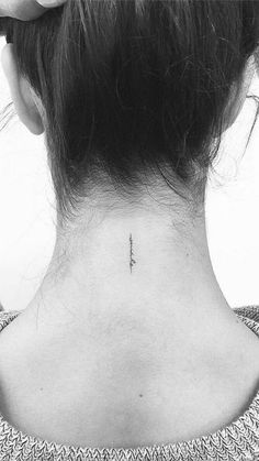 the back of a woman's neck with an arrow tattoo on it