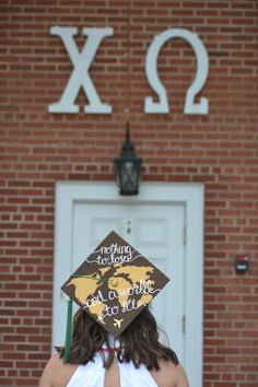 a woman wearing a graduation cap with the words x2 on it in front of a brick building