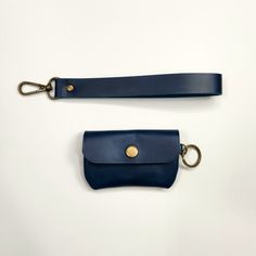 two blue leather purses with gold hardware on white background, one has a keychain and the other has a clip