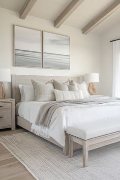 a large white bed sitting in a bedroom next to two paintings