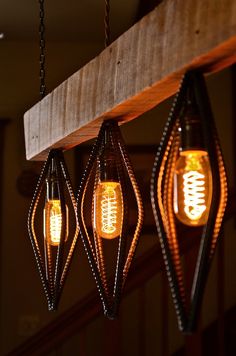 three light bulbs hanging from a wooden beam in a room with wood and metal accents