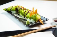 a plate with sushi and chopsticks on it