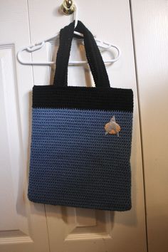 a blue and black bag hanging on a door