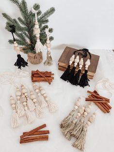 various wooden beads and tassels are arranged on a table next to a potted pine tree