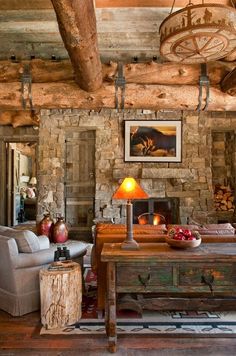 a rustic living room with stone fireplace and wood beams on the ceiling is furnished with an old - fashioned coffee table