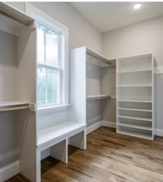 an empty walk in closet next to a window