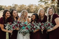 a group of women standing next to each other holding bouquets