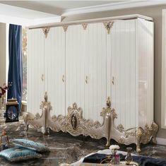 an ornately decorated bedroom with white and gold furniture