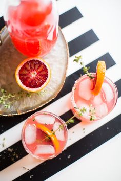 two glasses filled with blood orange margaritas and garnish