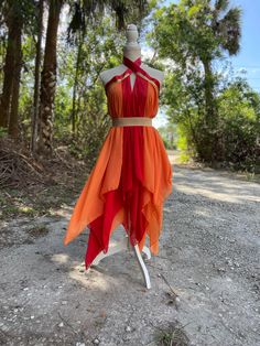 an orange and red dress sitting on top of a mannequin