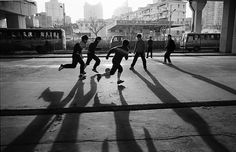 black and white photograph of skateboarders in an urban setting with shadows on the ground