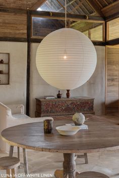 a dining room table and chairs in front of a large white ball hanging from the ceiling