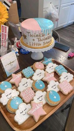 decorated cookies on a wooden tray next to a cake and greetings for someone's special occasion