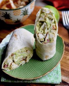 a burrito cut in half on a green plate