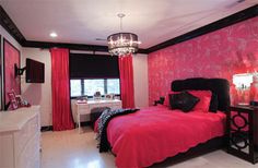 a bedroom decorated in pink and black with a chandelier