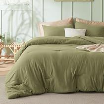 a bed with green sheets and pillows in a room