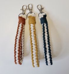 three different colored rope key chains hanging from hooks