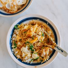 two bowls filled with rice and vegetables on top of a white countertop next to each other