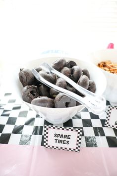 a bowl filled with chocolate covered donuts on top of a checkered table cloth