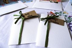 three cards with green ribbons tied to them