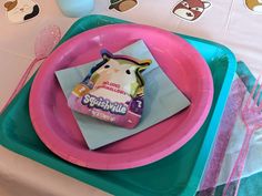 there is a pink plate on the table with an animal napkin holder in front of it