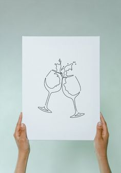 someone holding up a card with two glasses of wine on it and the image is drawn in black ink